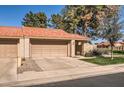 Exterior view of a tan home with a red tile roof, garage, driveway and tidy front lawn at 945 N Pasadena -- # 52, Mesa, AZ 85201