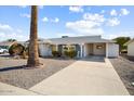 Classic home with desert landscaping and a covered carport, complemented by a mature palm tree at 10423 W Monterosa Dr, Sun City, AZ 85351