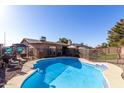 Private backyard features a sparkling pool with a safety fence and patio area at 1353 N Avoca --, Mesa, AZ 85207