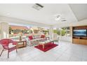 Bright living room with large windows, tile flooring, and a comfortable seating area with a TV at 13548 W Whitewood Dr, Sun City West, AZ 85375