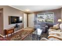 Relaxing living room features a large TV, comfortable seating, and natural light at 13633 N 111Th Ave, Sun City, AZ 85351