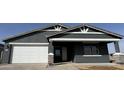 A home's exterior with a grey stucco facade, a two-car garage, a stylish white trim, and a covered porch at 15762 W Cheryl Dr, Waddell, AZ 85355