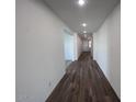 Long hallway with wood-look flooring and recessed lighting leads to the home's entrance at 15762 W Cheryl Dr, Waddell, AZ 85355
