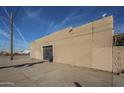 The tan stucco exterior features a secure steel door on the main side of the commercial building at 1610 W Buckeye Rd, Phoenix, AZ 85007