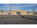 A side view of the tan stucco exterior shows a secure steel door of the commercial building across a city street at 1610 W Buckeye Rd, Phoenix, AZ 85007