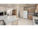 Open kitchen featuring an island with seating, stainless steel sink, and modern white refrigerator at 16643 N 19Th St, Phoenix, AZ 85022