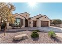 Lovely home with desert landscaping, seating on the porch, and a 3-car garage at 16713 W Monte Vista Rd, Goodyear, AZ 85395