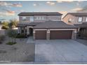 Two-story home featuring a three-car garage, desert landscaping, and a welcoming entrance at 17441 W Rock Ledge Rd, Goodyear, AZ 85338