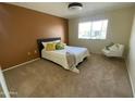 Well-lit bedroom with a queen bed, comfortable carpet, and a modern chair at 18841 N Palomar Dr, Sun City West, AZ 85375