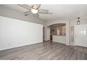 Spacious living room with hardwood floors, neutral walls, and a decorative ceiling fan at 21511 N 79Th Dr, Peoria, AZ 85382