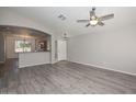 Bright living room showcasing stylish hardwood floors, archway and open-concept design at 21511 N 79Th Dr, Peoria, AZ 85382