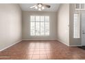 Bright living room featuring a ceiling fan, large windows, and tiled floors at 21732 N 86Th Ln, Peoria, AZ 85382