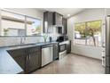 Bright kitchen featuring stainless steel appliances, dark cabinets, light backsplash, and a large window at 21824 N 32Nd Ave, Phoenix, AZ 85027