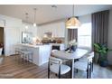 Eat-in kitchen featuring white cabinets, stainless steel appliances, island, and dining table at 2195 N Peden Dr, Chandler, AZ 85225