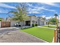 Charming home showcasing a well-manicured lawn, modern gray paint, and a paver driveway at 3007 N 47Th St, Phoenix, AZ 85018