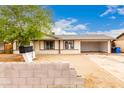 Single-story home features a low block wall and a 2-car garage at 3042 N 87Th Ave, Phoenix, AZ 85037