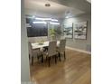 Bright dining room featuring modern lighting fixture, table, and hardwood floors at 30600 N Pima Rd # 19, Scottsdale, AZ 85266