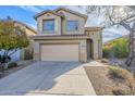 Home's front exterior showcases a two-car garage, desert landscaping, and a large paved driveway at 39237 N Acadia Way, Anthem, AZ 85086