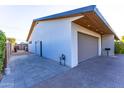 Modern garage with a sleek door, paver driveway, and contemporary architectural details at 3931 E Glenrosa Ave, Phoenix, AZ 85018