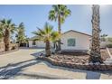 Exterior shot of a home with stucco, xeriscape landscaping, and palm trees at 4501 E Osage Ct, Phoenix, AZ 85044