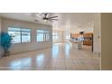 Bright open-concept living room with ceiling fan, tile flooring and a view into the kitchen at 4541 N 129Th Dr, Litchfield Park, AZ 85340
