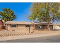 Single story brick home with mature desert landscaping and solar panels at 4550 W Bloomfield Rd, Glendale, AZ 85304