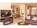 Living room with beige walls with a brown sofa with throw pillows, a TV, and a dining table set at 5705 S Pinnacle Ln, Gold Canyon, AZ 85118