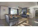 Bright living room features a ceiling fan, a built-in entertainment center, and seamless access to the patio at 6014 W Bent Tree Dr, Phoenix, AZ 85083