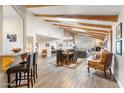 Open-concept living room with wood floors, high ceilings, fireplace and bar seating area at 9221 E Whitethorn Cir, Scottsdale, AZ 85266