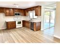 Well-equipped kitchen with stainless steel appliances, wood cabinets, and laminate floors at 1109 E Emerald Ave, Mesa, AZ 85204