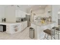 Bright kitchen featuring white cabinets, granite countertops, stainless steel appliances, and tile flooring at 11115 E Bellflower Ct, Sun Lakes, AZ 85248