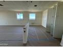 Spacious living room under construction showing windows, doorway and taped walls ready for finishing touches at 15744 W Beryl Ave, Waddell, AZ 85355