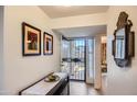 Well-lit foyer featuring modern decor, a sleek table, and a view to the outdoors at 18624 N 92Nd Dr, Peoria, AZ 85382