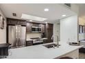 Bright kitchen with stainless steel appliances, gray counter tops, and a skylight for ample natural light at 18624 N 92Nd Dr, Peoria, AZ 85382