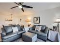 Inviting living room with stylish gray sofas, soft lighting, and views of the adjacent dining area at 18624 N 92Nd Dr, Peoria, AZ 85382