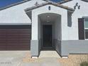 Inviting home entrance with a covered front porch and neutral color palette at 20328 N 225Th Dr, Surprise, AZ 85387