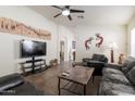 Inviting living room with comfortable seating, a ceiling fan, and artwork enhancing the cozy atmosphere at 24816 N Good Pasture Ln, Florence, AZ 85132