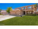 Charming two-story home with a three-car garage, well-manicured lawn, and welcoming facade at 2535 E Saratoga St, Gilbert, AZ 85296