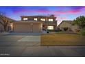 Two-story home with tile roof, balcony, three-car garage and manicured lawn at dusk at 2535 E Saratoga St, Gilbert, AZ 85296