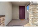 Covered porch with plum-colored front door, stacked stone columns, and a 