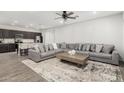 Open-concept living room featuring a gray sectional, a ceiling fan, and wood-look tile floors at 2622 E Monument Canyon Ave, Apache Junction, AZ 85119