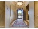 Grand foyer with arched doorway, ornate front door, and statement light fixture at 27701 N Lucero Dr, Rio Verde, AZ 85263