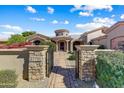 Stunning gated entrance with stone pillars, walkway, and lush landscaping leads to the front door at 27701 N Lucero Dr, Rio Verde, AZ 85263