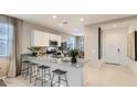 Modern kitchen featuring a granite island with bar stool seating, stainless steel appliances, and white cabinetry at 3266 E Baler Dr, San Tan Valley, AZ 85140