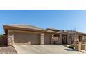 Charming single-story home featuring a desert landscape, a stone facade, and a three-car garage at 42043 N Bradon Way, Phoenix, AZ 85086