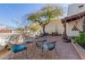 Charming front patio featuring brick pavers, wrought iron furniture, and lush desert landscaping at 44706 N 10Th Way, New River, AZ 85087