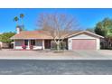 Charming single-story home with a manicured lawn, desert landscaping, and a neatly painted two-car garage at 4506 E Arapahoe St, Phoenix, AZ 85044