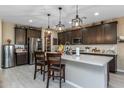 Modern kitchen with stainless steel appliances, island with seating, and ample cabinet space at 4588 W Suncup Dr, San Tan Valley, AZ 85144