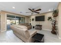 Spacious living room featuring neutral tones, ceiling fan, and access to outdoor patio at 4588 W Suncup Dr, San Tan Valley, AZ 85144