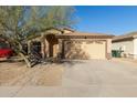 Charming single-Gathering home with a two-car garage, desert landscaping, and mature tree at 6042 W Warner St, Phoenix, AZ 85043